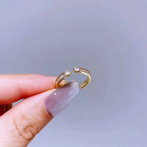 Close-up of golden adjustable ring with double zircon stones and crystal accents