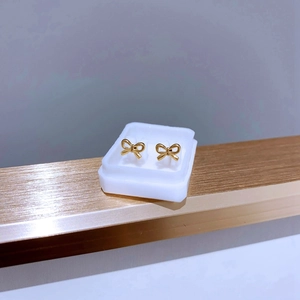 Nahaufnahme goldener Schleifen-Ohrstecker aus Titanstahl für einen minimalistischen Look