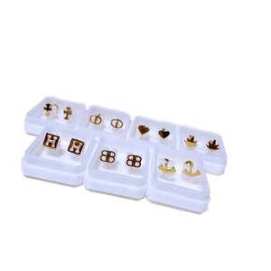 Minimalistisches Ohrstecker-Set aus goldenem Titanstahl mit Logo-Mustern in Schaukästen