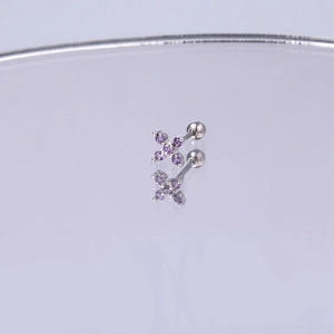 Makroaufnahme von Silberkreuz-Piercingstecker mit vier lila Zirkonia und Schraubverschluss