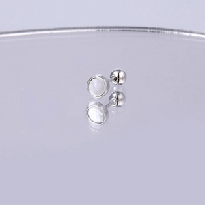 Detailaufnahme eines silbernen Titan-Ohrsteckers mit schillerndem weißen Perlmutt-Inlay