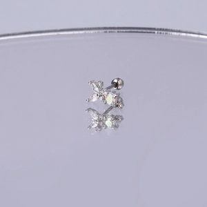 Nahaufnahme von silbernem Schmetterlings-Ohrstecker mit Zirkonia und Opalstein