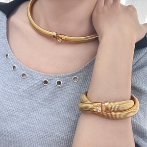 Detail of 18K gold plated Tubogas snake chain necklace and bangle with zircon clasp