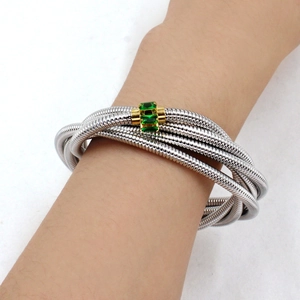 Detail of multi-layer spiral textured bracelet featuring green zircon stone inlay
