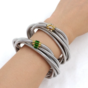 Detail of silver spiral multi-layer snake bone bracelet with green and white zircon accents