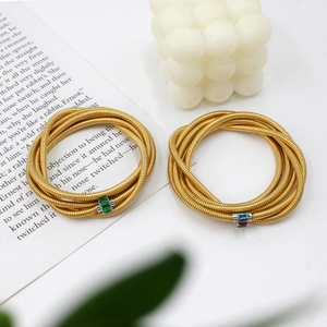 Detailed macro view of gold-plated coiled snake bracelets with colorful cubic zirconia
