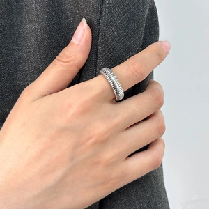 Macro shot of silver ribbed geometric ring with textured metallic spiral details