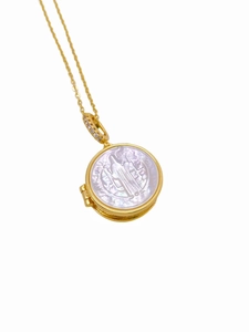 Macro shot of 18K gold plated necklace with shell religious pendant and pavé zircon clasp