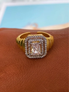 Détail macro d'une bague zircon carrée avec halo de diamants à deux niveaux et texture