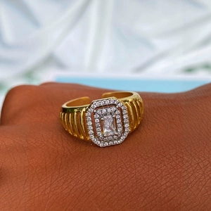 Bague dorée pour homme avec halo de zircon et texture rayée sur la main d'un modèle
