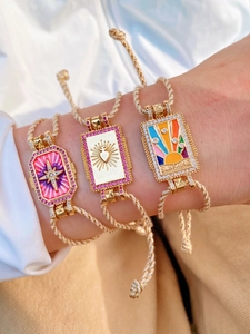 Gros plan de bracelets tarot bohèmes avec étoile à huit branches et breloques en émail