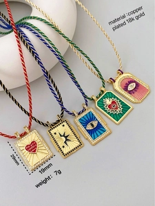 Detail of tarot card pendants in 18k gold plated copper with colorful enamel symbols