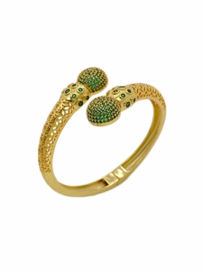 Detail eines goldenen Armreifs mit grünen Zirkonia-Kugeln und filigranen Blumenmustern