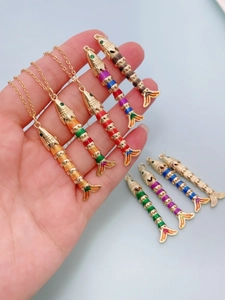 Detailed macro shot of flexible gold-tone fish pendants with colorful enamel joints