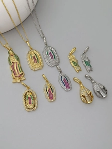 Vista macro de colgantes de Jesús en oro y plata con micro-incrustaciones de circonitas