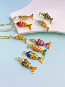 Macro shot of flexible multi-jointed gold koi fish pendants with colorful enamel scales
