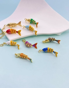Detail view of colorful enamel koi fish pendants with gold plated scales on a white tray