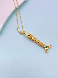 Detailed macro view of golden fish pendant necklace with colorful enamel and jointed body