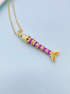 Macro shot of colorful articulated fish pendant on a gold chain with vibrant purple enamel