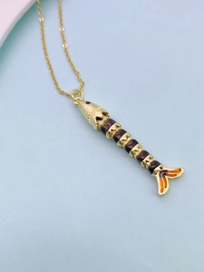 Macro view of articulated fish pendant with gold frame and vibrant enamel details