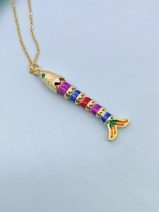 Macro shot of colorful enamel articulated fish pendant with gold plating and green zircon eye