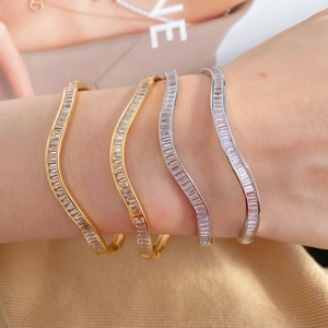Luxuriöser Wellenarmreif mit Zirkonia im Baguetteschliff in Gold und Silber
