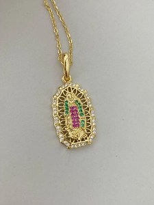 Detalle de collar dorado con colgante ovalado de Virgen María y cristales de colores