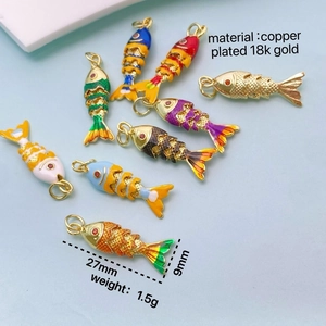 Colorful fish pendants in copper plated 18k gold with detailed scales and red stone eyes