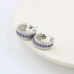 Dettaglio di orecchini a cerchio a C intrecciati argento con zirconi viola e chiusura metallo