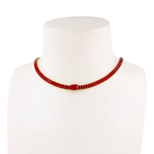 Détail d'un collier ras de cou doré orné de gemmes rouges rectangulaires sur un mannequin