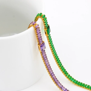 Détail de chaînes tennis dorées serties de zircons rectangulaires violets et verts