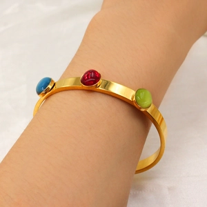 Detail of 18k gold plated stainless steel cuff with blue, red and green oval zircons