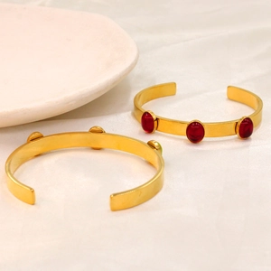 Detail of 18k gold plated stainless steel cuff with three red oval gemstones