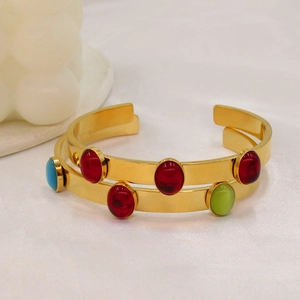 Detailed macro view of 18k gold-plated cuff featuring vibrant oval-cut colorful gemstones