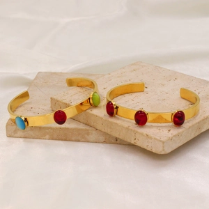 Detailed view of 18k gold plated bangles featuring oval colorful zircon stones on stone steps