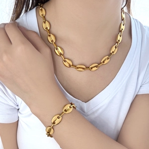 Nahaufnahme von goldenem Kaffeebohnen Halskette und Armband Set an einem Model