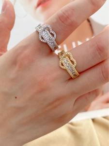 Détail de bagues cœur entrelacées en or et argent avec pavé de pierres de zircon