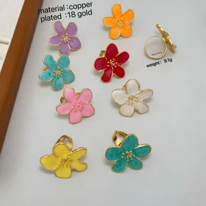 Macro detail of adjustable camellia flower rings in 18K gold plated copper with enamel