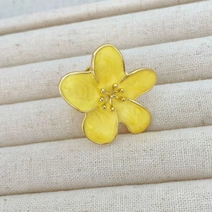 Macro shot of camellia ring showing yellow enamel marble texture and golden flower petals
