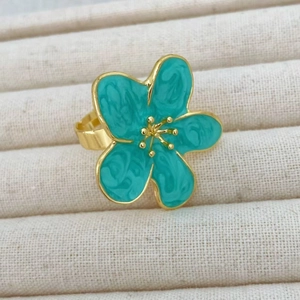 Close-up of golden camellia ring with teal enamel petals and marble texture detail