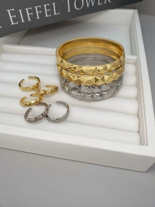 Detalle del conjunto de joyas en oro y plata con patrón de pirámide geométrica