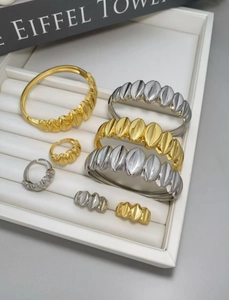 Vista detallada del conjunto de brazalete y anillo minimalista irregular en oro y plata