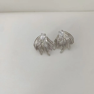 Detailed macro view of silver angel wing stud earrings with sparkling cubic zirconia stones