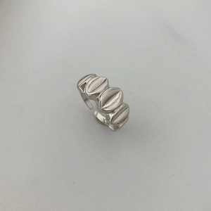 Detalle de anillo abierto plateado minimalista con textura 3D ovalada vertical única