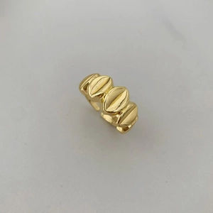 Vista detallada del anillo dorado con eslabones de grano de café y acabado de alto pulido