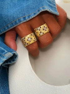 Macro shot of brushed gold-tone wide ring with hollow clover pattern and small diamonds