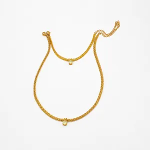 Detalle de dos collares bañados en oro de 18K con colgantes de circón verde claro