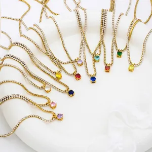 Detail of diverse birthstone pendant necklaces with gold plating arranged on a plate