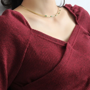 Gros plan d'un collier vintage français en or 18 carats avec zircon émeraude sur un mannequin