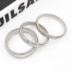 Detailed view of silver stainless steel stretch tubogas coil bracelets in a set of three